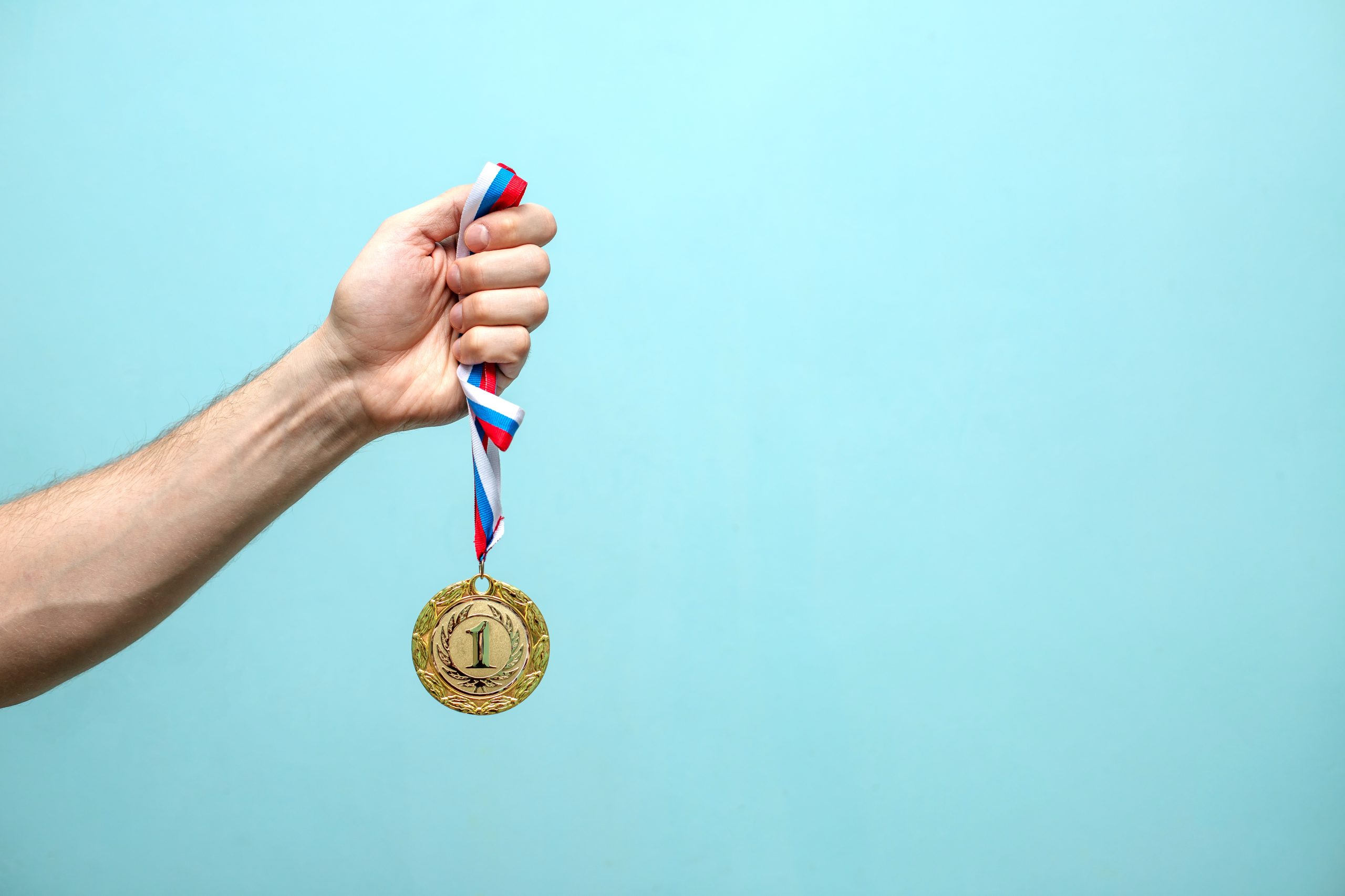 Przyszły pan młody z medalem na podium po wyścigu gokartowym z przyjaciółmi.